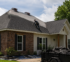 Professional roof repair near a Youngsville, Louisiana home with roofing contractors replacing shingles on a residential roof after storm damage.